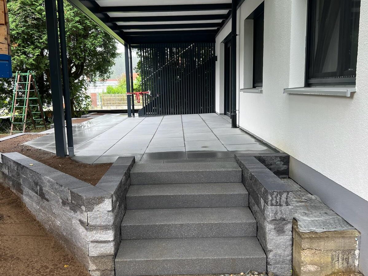 Moderne Granitstufen mit Terrassenueberdachung und Natursteineinfassung