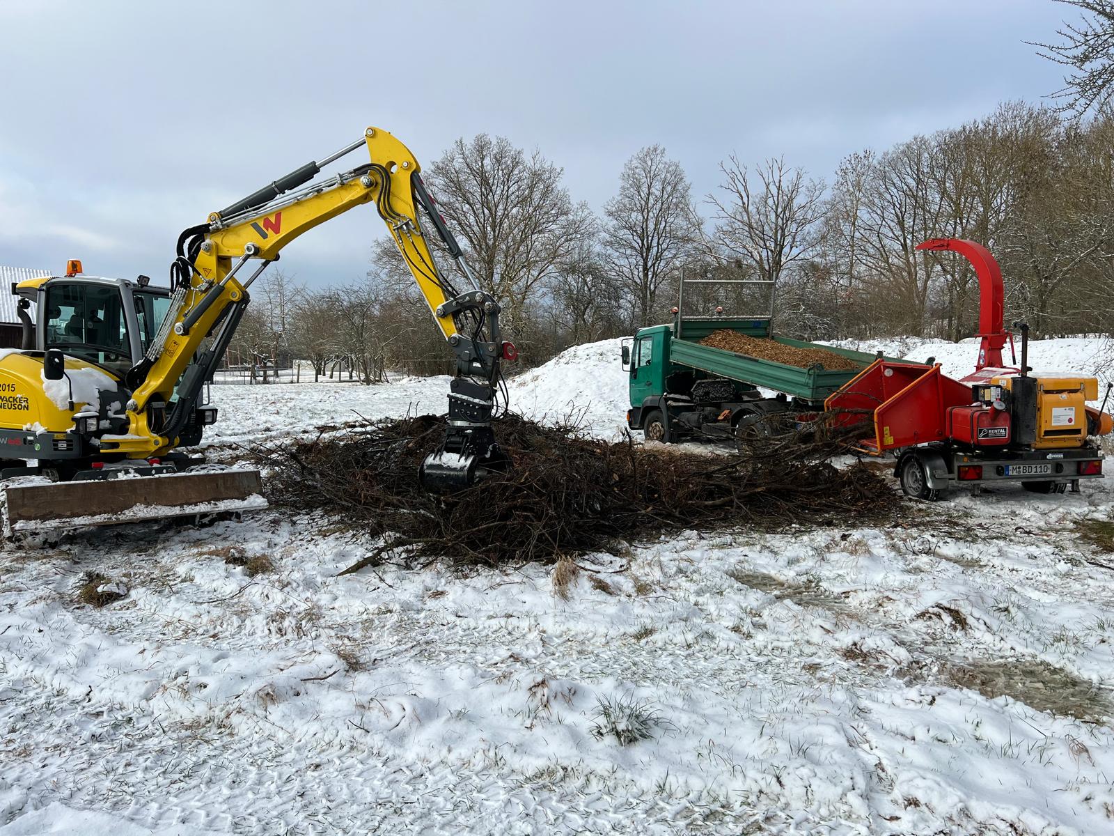 Bagger und Haecksler bei Rodungsarbeiten im Winter